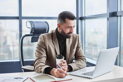 businessman with a takeaway coffee works with documents. close-up.