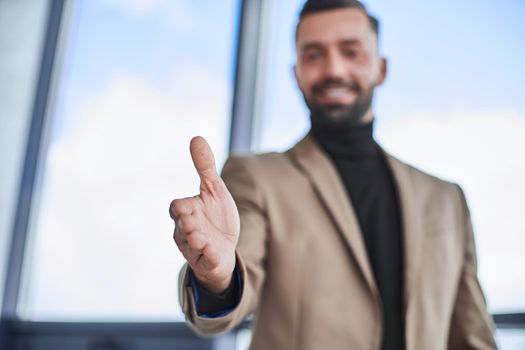 close up. smiling man offering you his handshake.