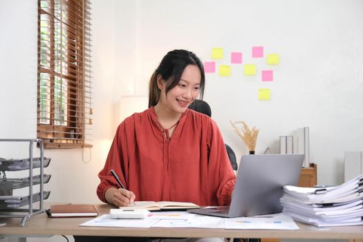 young woman working on laptop or notebook in her office. Beautiful Freelancer Woman working online at her home. Beauty Asian business woman concept