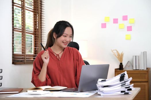 young woman working on laptop or notebook in her office. Beautiful Freelancer Woman working online at her home. Beauty Asian business woman concept