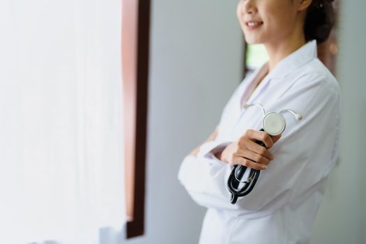 Portrait of an Asian female doctor smiling happily holding a stethoscope after a break from work.