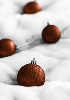 Gift decor, New Years Eve and happy celebration concept - Chocolate brown Christmas baubles on white fluffy fur backdrop, luxury winter holiday design background
