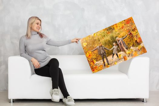 woman holding a photo of autumn, canvas.