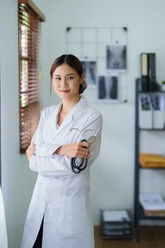 Portrait of an Asian female doctor smiling happily holding a stethoscope after a break from work.