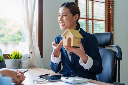 Portrait of a real estate agent or bank officer, the lending department quotes the interest on the loan to the customer to assess the risk of investing in a home.