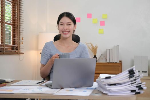 Portrait of Young woman using laptop computer at the office, Student girl working at home. Work or study from home, Asian woman freelance, business, lifestyle concept.