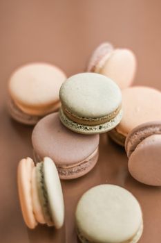 Pastry, bakery and branding concept - French macaroons on cream beige background, parisian chic cafe dessert, sweet food and cake macaron for luxury confectionery brand, holiday backdrop design