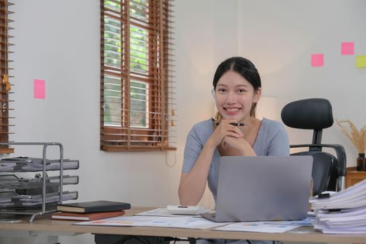 Portrait of Young woman using laptop computer at the office, Student girl working at home. Work or study from home, Asian woman freelance, business, lifestyle concept.