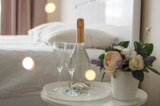 Two glasses and a bottle of champagne in a hotel room. Dating, romance, honeymoon, Valentine's day.