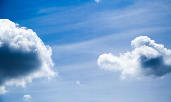 Summer sky. Cumulus clouds on a blue background. Partly cloudy. Dark clouds and white clouds.