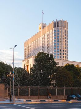 MOSCOW, RUSSIA - September 17, 2022. People go pass the White House, The House of the Government of the Russian Federation. Famous building at autumn sunset.