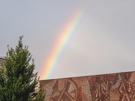 MOSCOW, RUSSIA - September 17, 2022.Bbright and colorful rainbow in the air. Cloudscape after rainfall over old cinema Oktyabr.