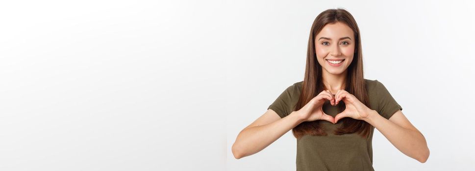 Smiling teenager girl making heart shape with her hands isolated on white