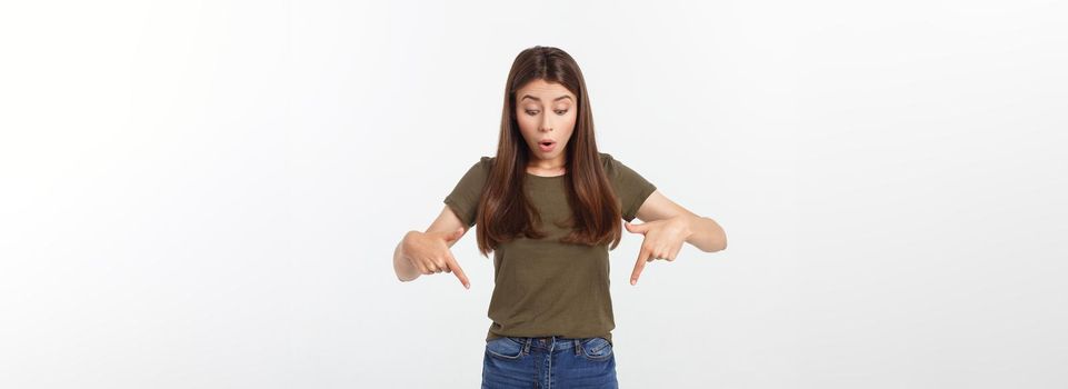 Portrait happy and surprised young lady standing isolated over grey background. Looking camera pointing