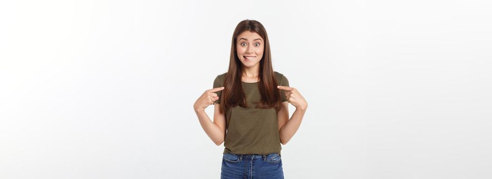 Portrait happy and surprised young lady standing isolated over grey background. Looking camera pointing