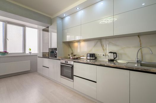 Interior of well designed modern trendy white kitchen