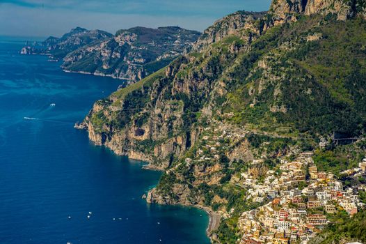 Aerial view of Positano in Italy with a spectacular background of blue clouds and colourful houses on the coast