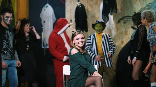 Halloween party, photo session, young people dressed up in scary costumes and made a horrific make-up. they are having fun, in the background Halloween scenery is seen. High quality photo
