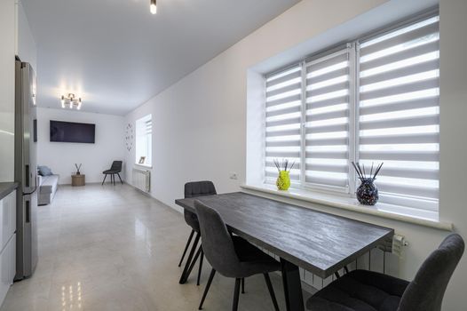 Luxurious modern trendy white and grey kitchen interior after renovation, with granite counter top