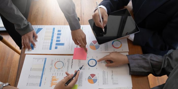 Teamwork with business people analysis cost graph on desk at meeting room..