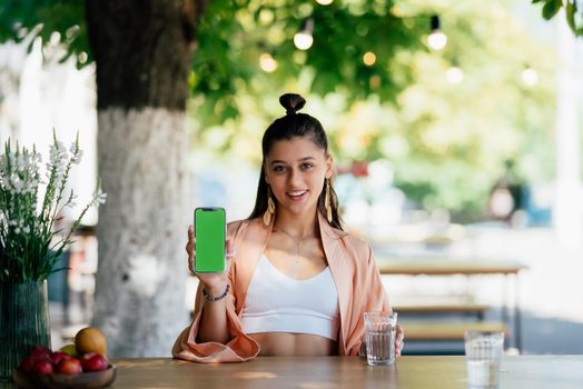 Happy woman hold smartphone. Green screen phone screen