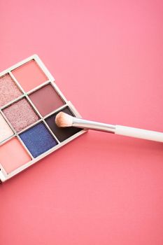 Cosmetic branding, mua and girly concept - Eyeshadow palette and make-up brush on coral background, eye shadows cosmetics product for luxury beauty brand promotion and holiday fashion blog design