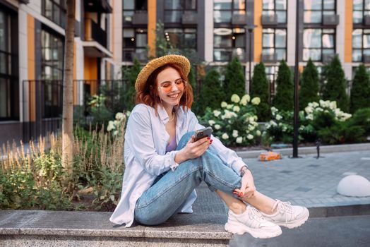 Photo of cute adorable young lady sitting stairs typing modern device outside urban city street
