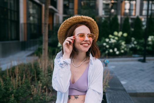 Close up portrait of a young caucasian woman with ginger red hair and toothy smile in outdoors