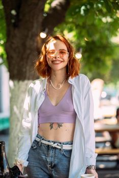 Close up portrait of a young caucasian woman with ginger red hair and toothy smile in outdoors