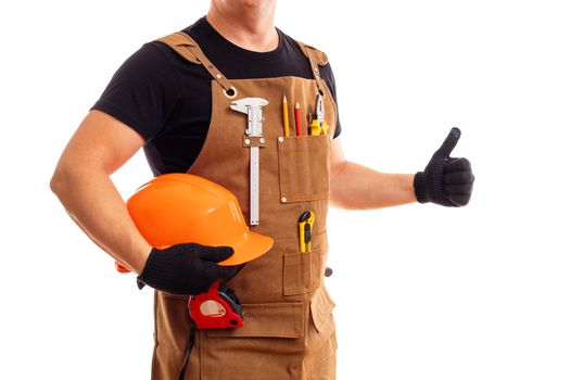 Contractor worker or carpenter in workers apron with tools and helmet holding thumbs up isolated on white background.