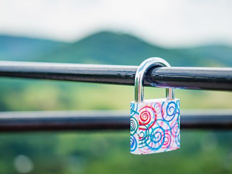 Locked red heart shaped padlock. Symbol of eternal love. Selective focus. The lock on handrail bar