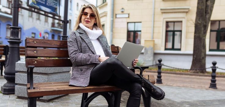 stylish business woman working on laptop online in the city.