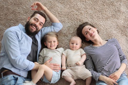 happy family mother father and kids at home. laying