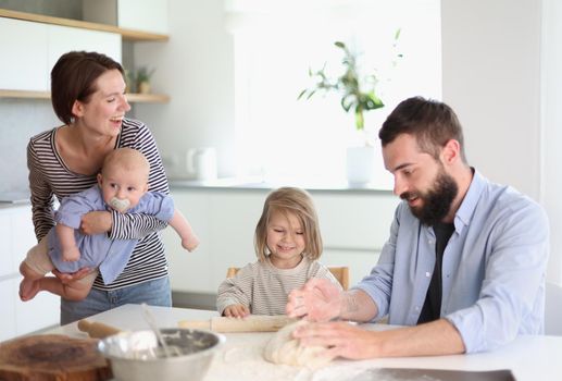 Young family with daughter and son in the kitchen