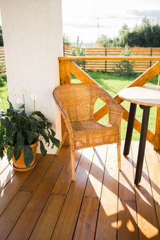 Cozy wooden terrace of country house or cottage with garden view - table and chair for relaxing evening. High quality photo