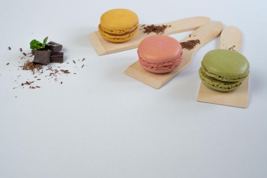 colorful macarons on white background with cup of coffee