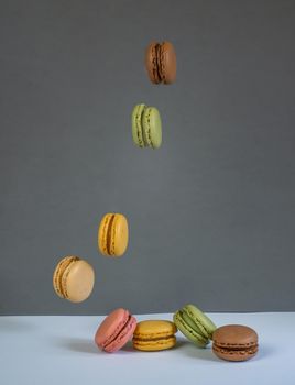 colorful macarons on white background with cup of coffee