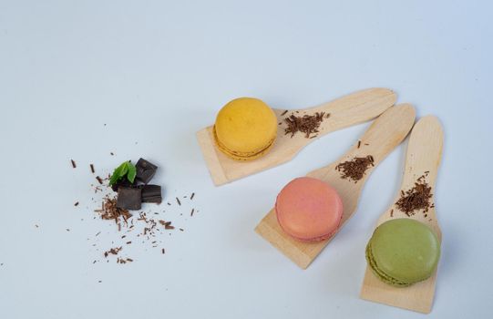 colorful macarons on white background with cup of coffee