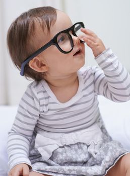 Shes destined for great things. A cute little baby girl wearing over-sized spectacles