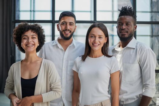 Portrait of successful creative business team looking at camera and smiling. Diverse business people standing together at startup.