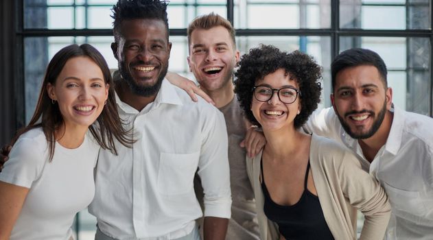 Portrait of successful creative business team looking at camera and smiling. Diverse business people standing together at startup.