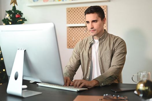 Confident businessman working with computer at home office.