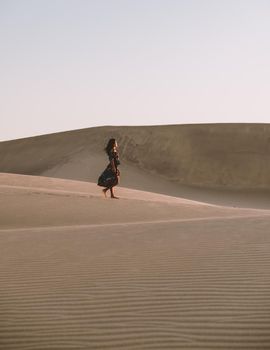 young woman at the dessert of Maspalomas sand dunes Gran Canaria during vacation at the Canary Islands. in Spain, Gran Canaria sand dunes