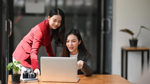 Two business women discussing the strategy plan together in office.