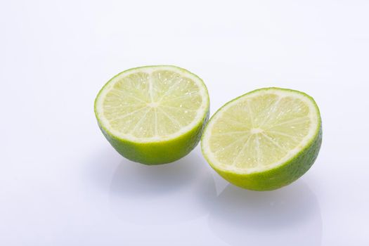 Fresh, natural, green limes cut in half isolated on a white background.