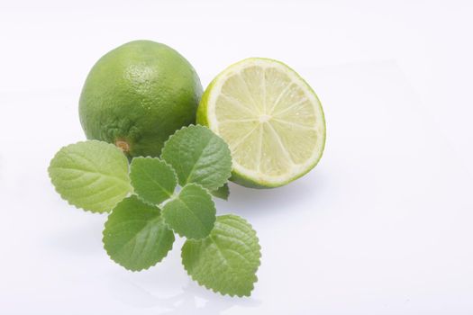 Fresh, natural, green limes, cut in half and whole, fresh mint on a white background.