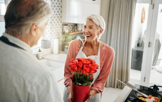 Flowers, love and cooking with a senior couple in a kitchen forsurprise breakfast in celebration of an anniversary, birthday or valentines day. Food, romance and morning with an elderly man and woman.