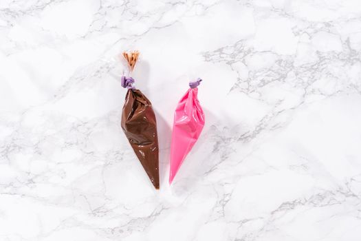 Flat lay. Melted chocolate in piping bags ready for drizzling over chocolate-covered strawberries.