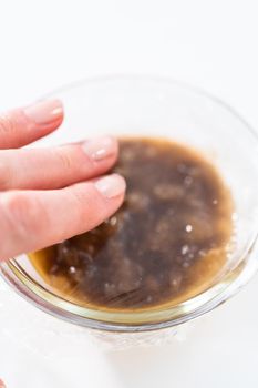 Mashed overripe banana in a glass mixing bowl.