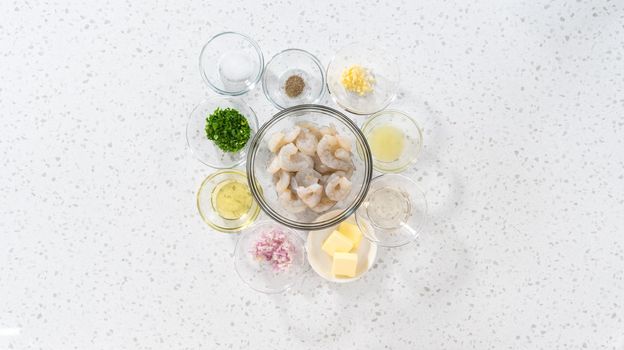 Flat lay. Measured ingredients in glass mixing bowls to make shrimp scampi with linguine pasta.